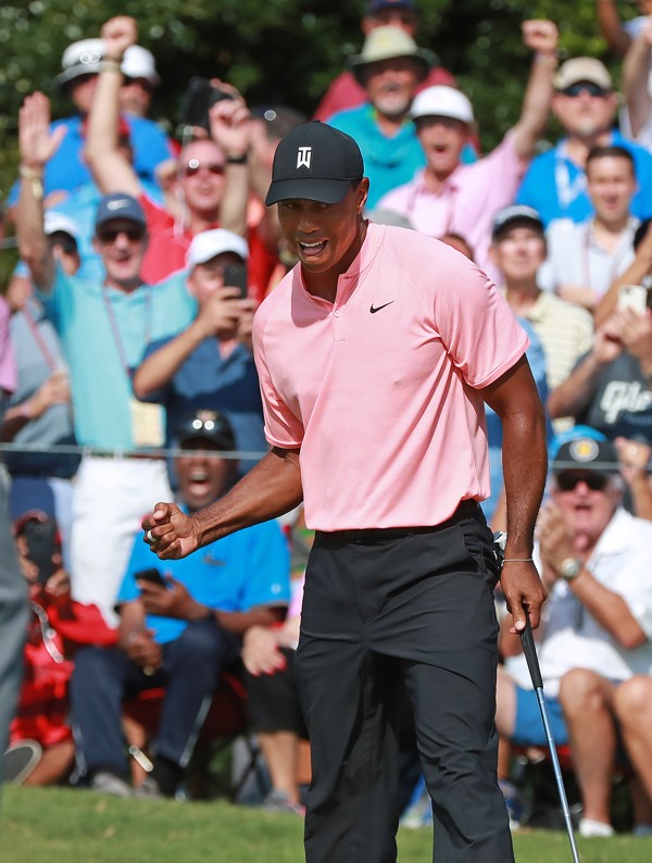Tiger Woods sinks his birdie putt on the 18th green. Photo: TNS