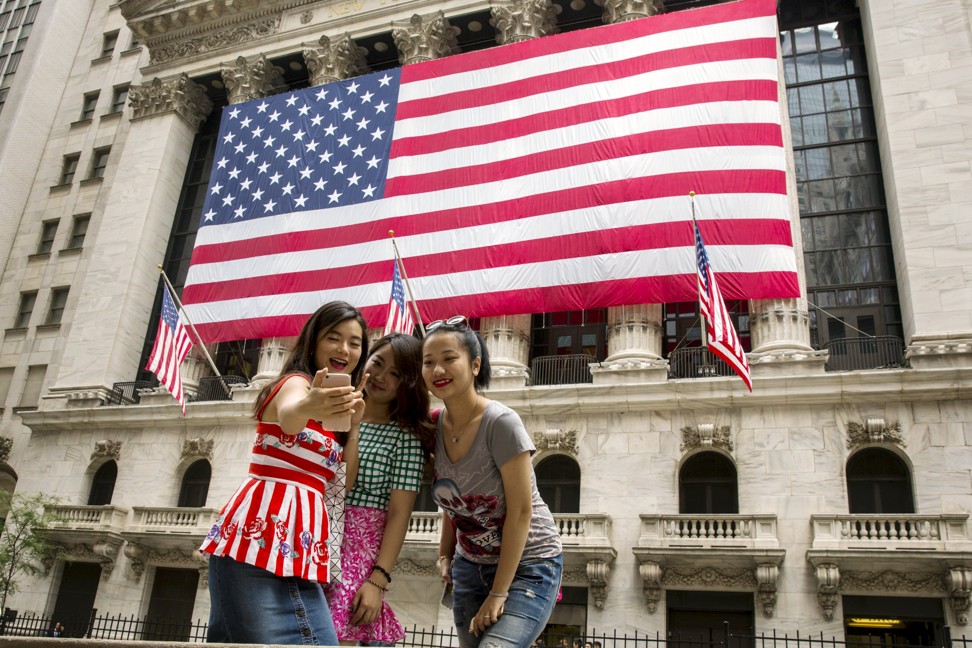 Chinese tourists take photographs outside the New York Stock Exchange. Photo: Reuters