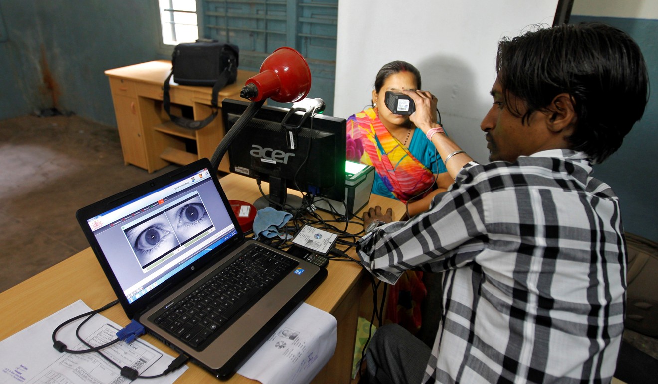 File photo of a woman looking through an optical biometric reader, which scans iris patterns, while registration for an Aadhaar card in Ahmadabad. Photo: Reuters