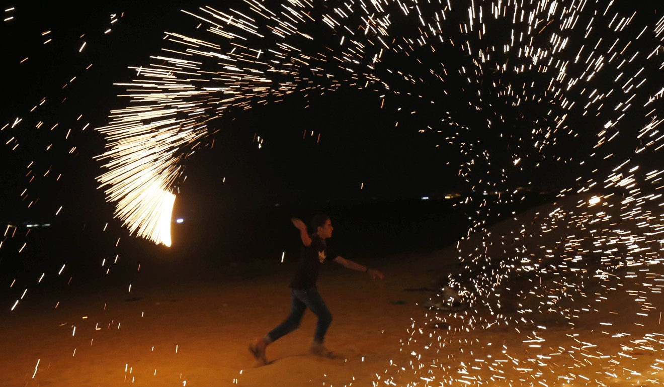 A Palestinian protester waves a sparkler near the Gaza-Israel border east of Rafah. Photo: AFP