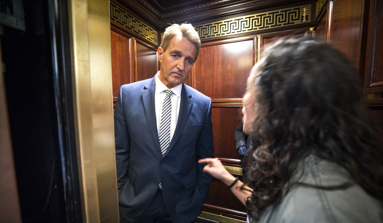 A woman who said she is a survivor of a sexual assault confronts Republican Senator Jeff Flake in a lift. Photo: EPA