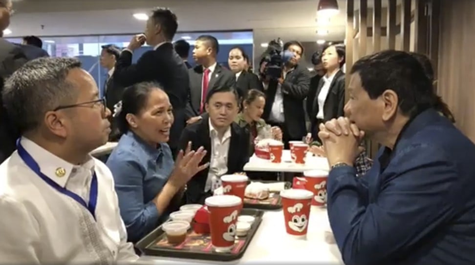 This screen grab image shows Philippine President Rodrigo Duterte, with hands crossed and wearing a jacket, listening to a maid at a Jollibee outlet in Hung Hom in April. Photo: Facebook