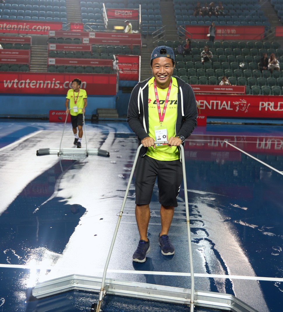 A staff member helps dry out Centre Court.