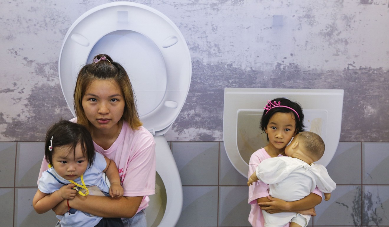 Moon Leung (left) and her two daughters pose at an exhibition at Times Square, Causeway Bay, in July that highlighted the challenges mothers face in trying to breastfeed. Many working mothers in Hong Kong breastfeed and pump breast milk in toilets in the absence of better facilities. Photo: Dickson Lee