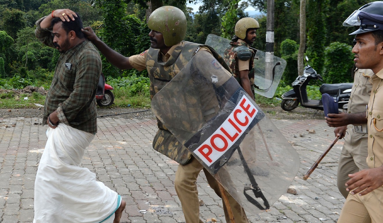 Indian police take a man into custody as protesters rallied against a Supreme Court verdict revoking a ban on women's entry to a Hindu temple in Kerala on Wednesday. Photo: AFP