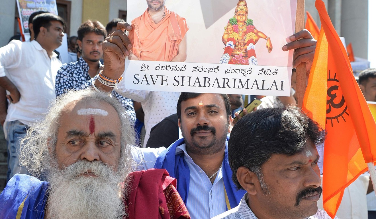Devotees of Hindu god Ayyappa hold posters of the deity at the rally in Bangalore. Photo: AFP