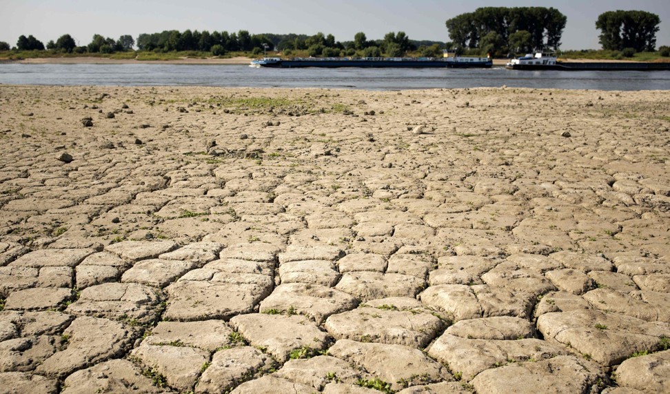 River barges past parched earth on the banks of the River Rhine at Lobith in the Netherlands on August 2, 2018, as heatwave conditions prevail over northern Europe. Photo: Agence France-Presse