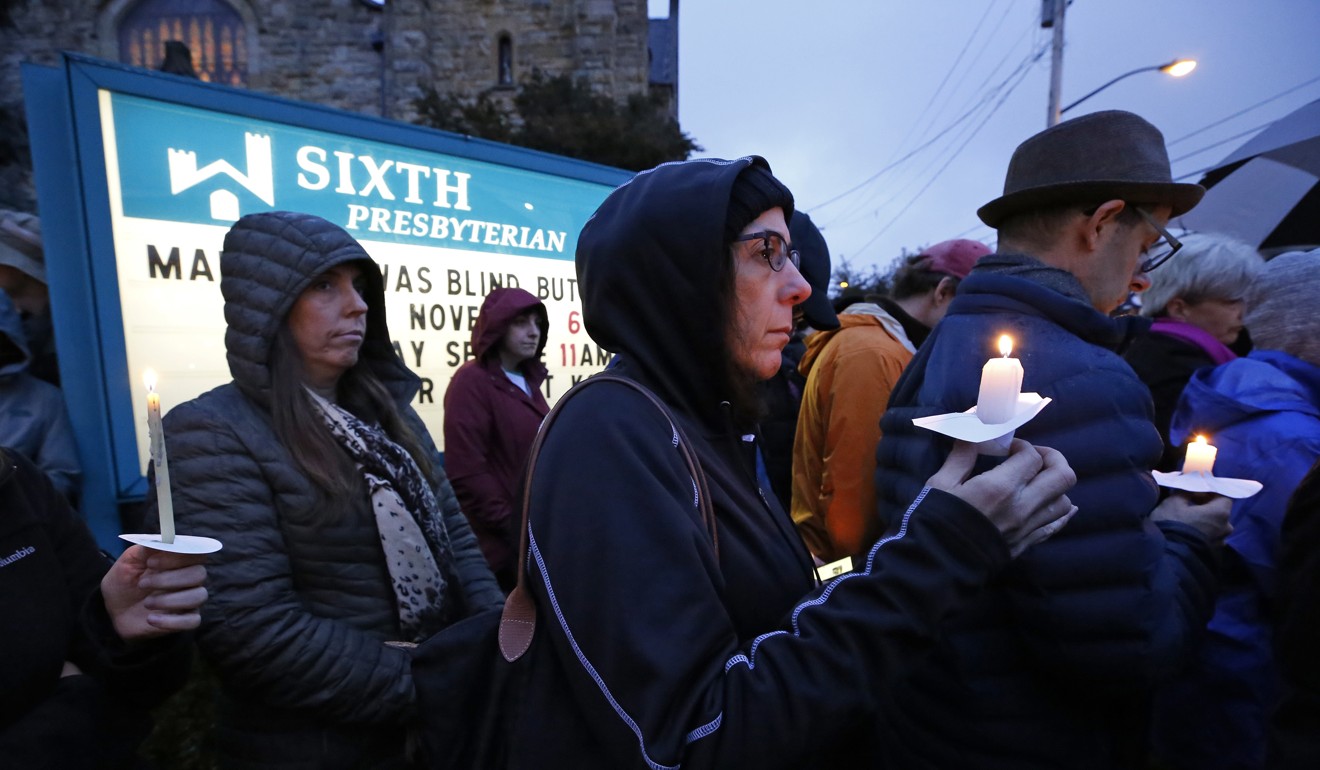 A crowd holds candles on the lawn of the Sixth Presbyterian Church at the intersection of Murray Ave. and Forbes Ave. in the Squirrel Hill section of Pittsburgh during a memorial vigil. Phot: AP Photo