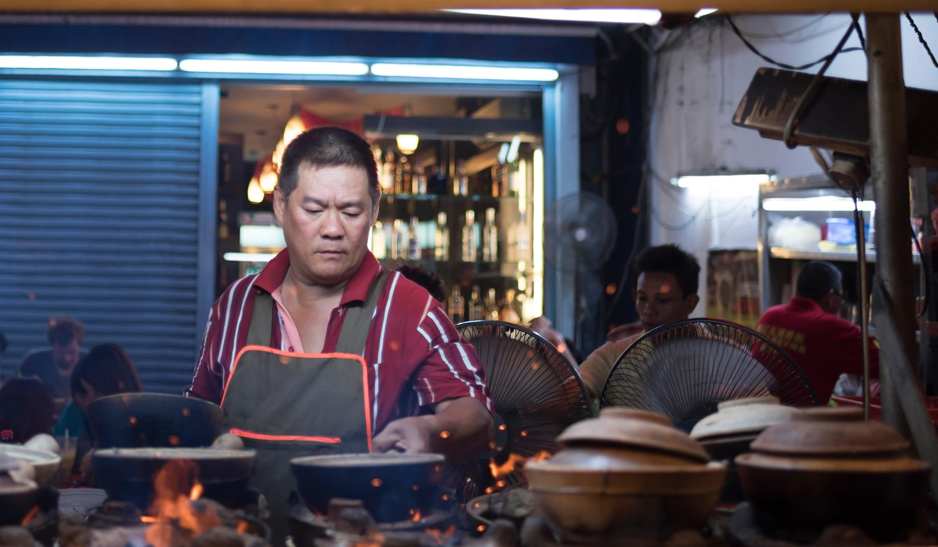 A chef at a street food stall in Kuala Lumpur’s Chinatown. Photo: Alamy