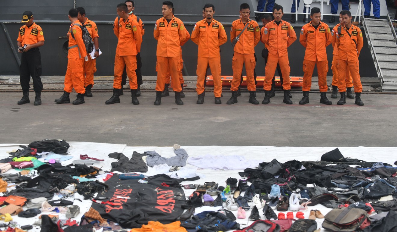 Recovered personal items of passengers from ill-fated Lion Air flight JT 610 are laid out as search and rescue personnel stand in formation on Tuesday. Photo: AFP