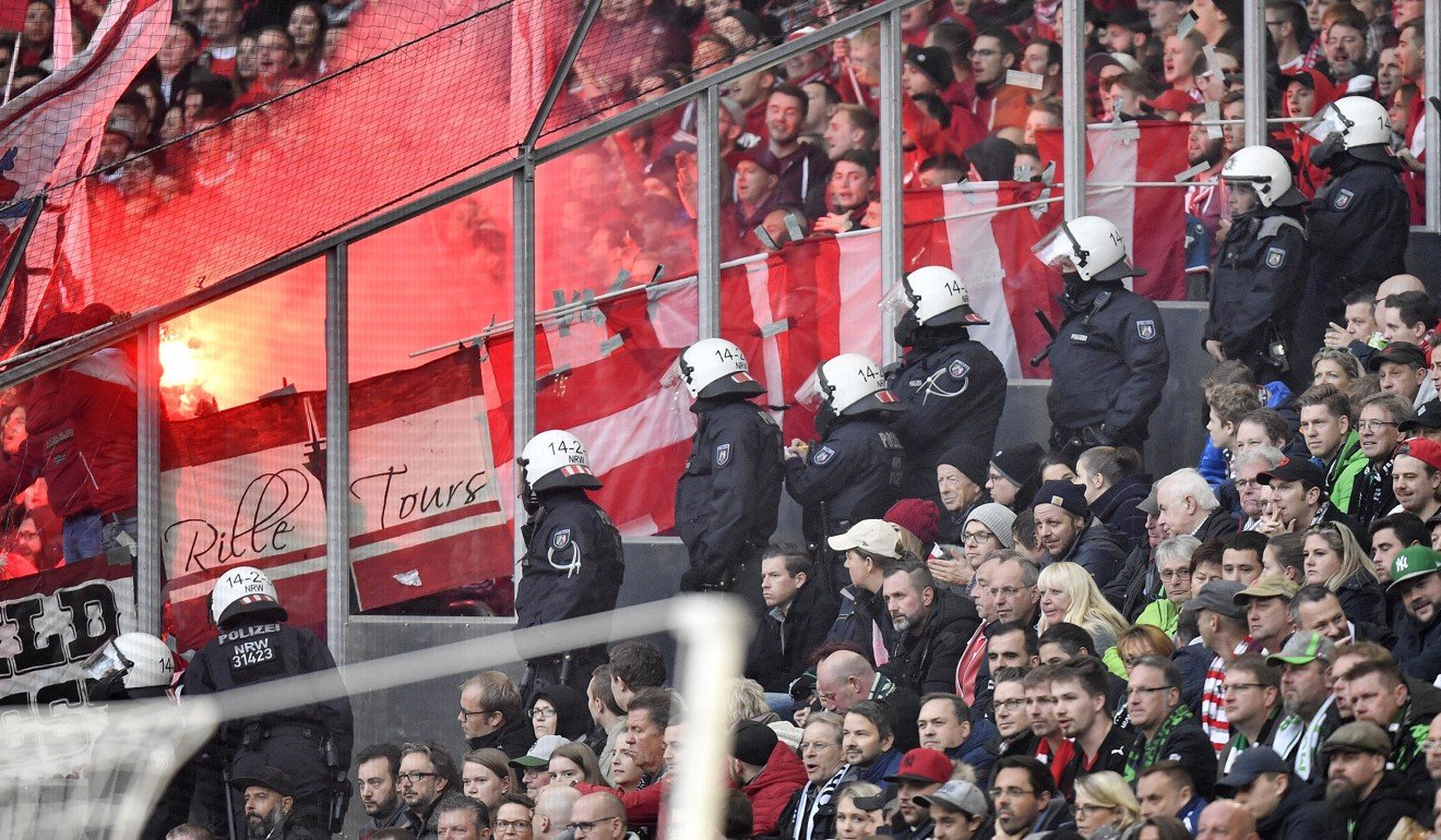Police watch Düsseldorf supporters burning flares during the German Bundesliga match against Borussia Moenchengladbach at the weekend. Photo: AP