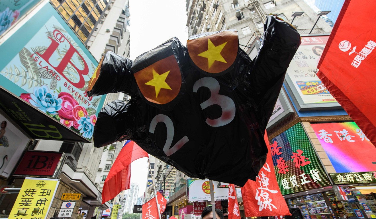 A figure, in the shape of a hand with the colours of the China national flag for fingernails and a ‘23’ on its palm with reference to the controversial Article 23 law, is carried by protesters at a National Day rally in Hong Kong on October 1. Photo: AFP