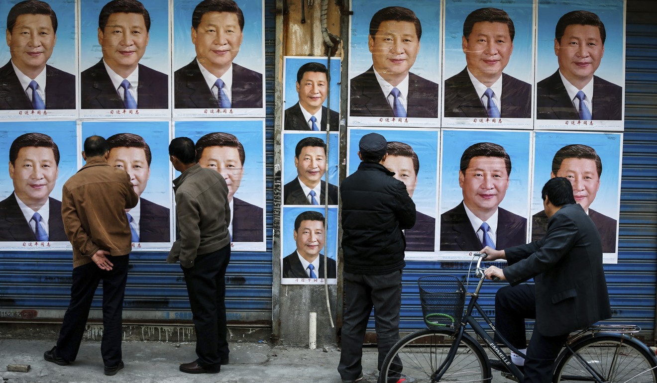 People look at a building covered in posters of Chinese President Xi Jinping in Shanghai, in March 2016. China has scrapped term limits on the presidency allowing Xi to continue in the post indefinitely. Photo: AP