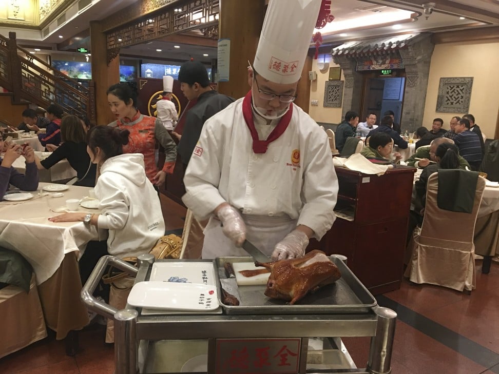 A chef carves a duck at Quanjude in Beijing. Photo: Elaine Yau