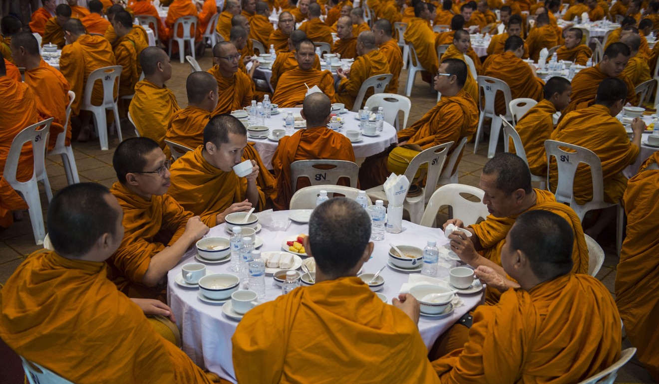 Buddhist monks eat at a royal ceremony in a government centre in Bangkok. Photo: AFP