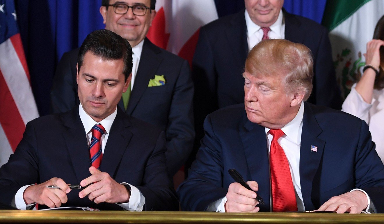 Trump watching as Nieto signed the pact on Friday morning. Photo: AFP