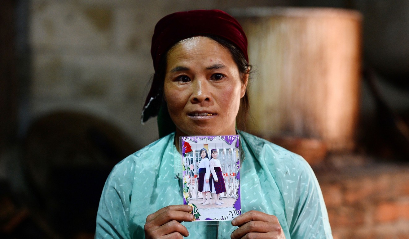Ly Thi My holds the picture of her daughter Di with Dua. Photo: AFP