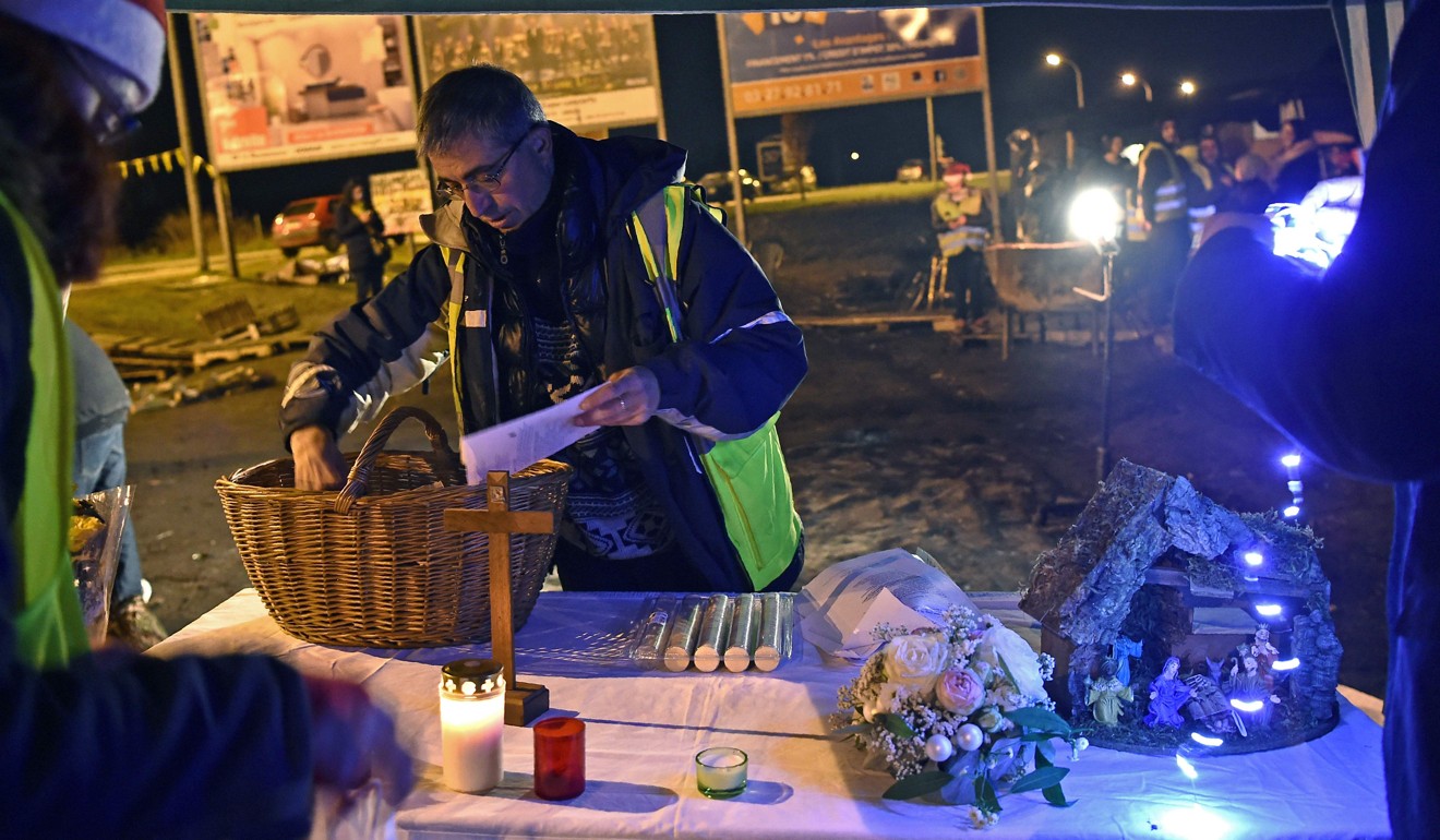 Priest Joseph Nurchi prepares for a Christmas mass for yellow vest protestors near a roundabout in Somain, northern France on December 24, 2018. Photo: AFP