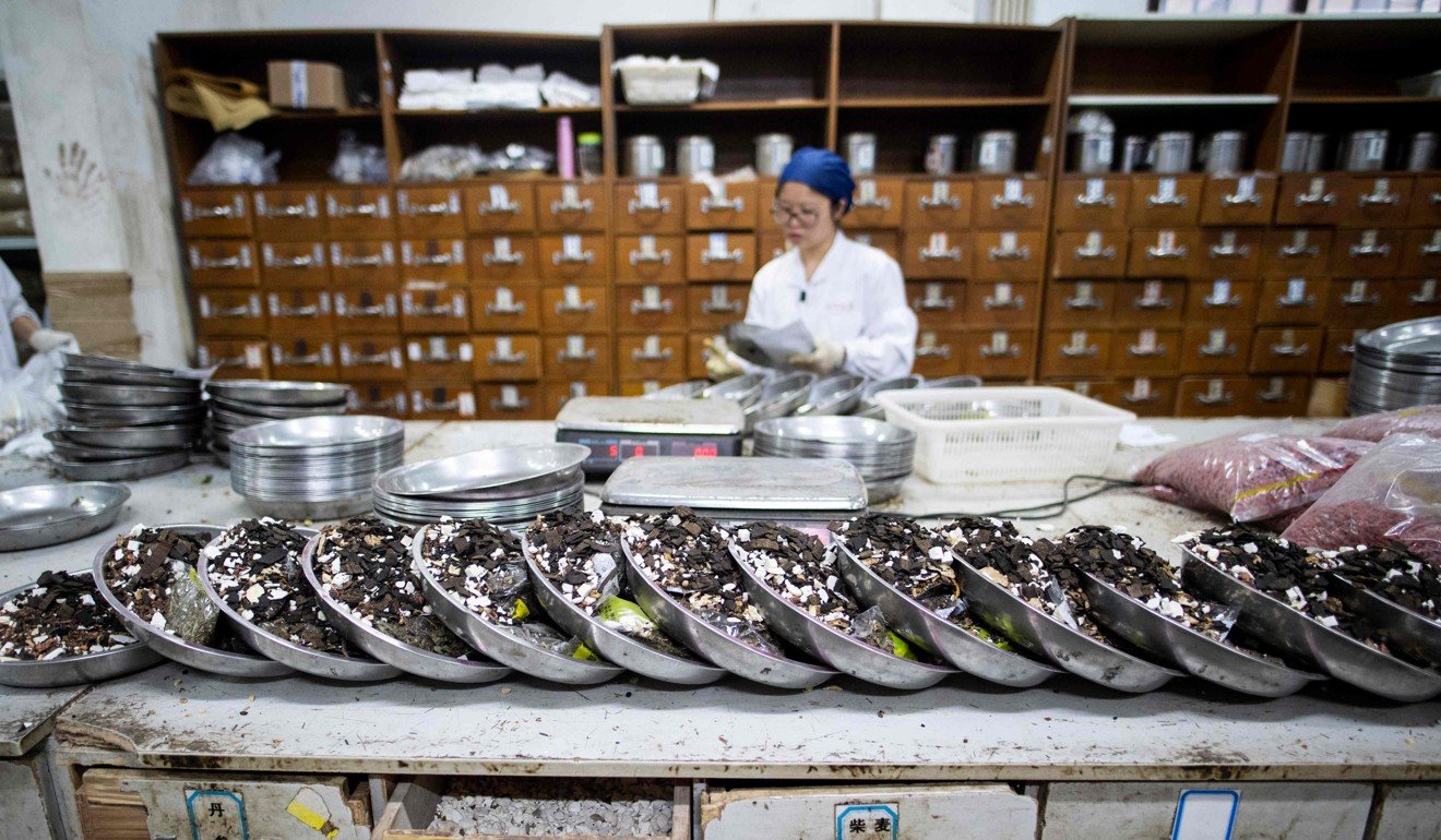 A woman mixes Chinese herbs in the pharmacy at Yueyang Hospital in Shanghai. Photo: AFP