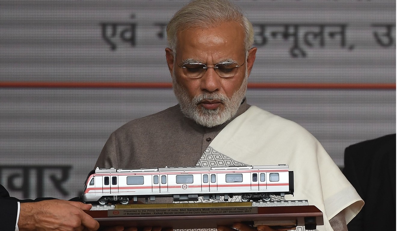 India Prime Minister Narendra Modi looks at a model of Metro train during the inauguration of a section of Delhi Metro in Noida, 25km east of New Delhi on December 25, 2017. Photo: AFP