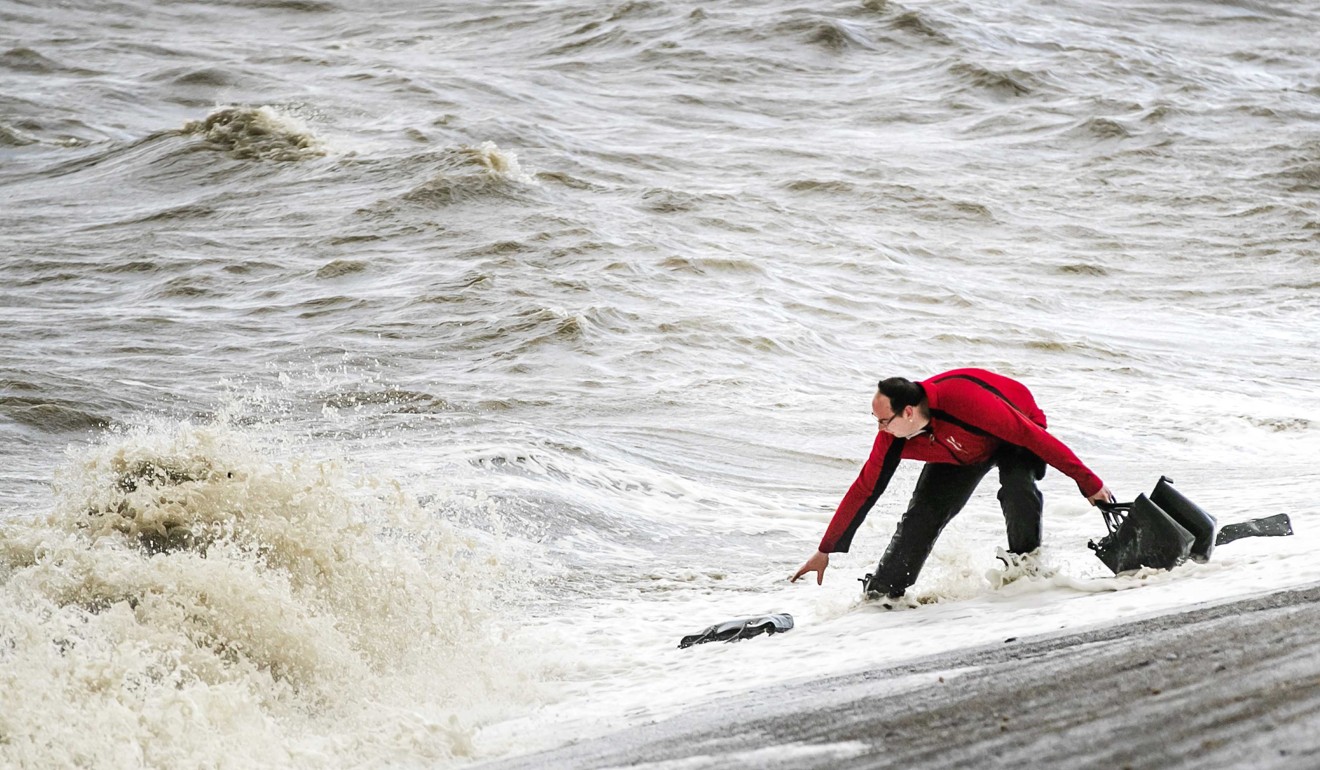 A man tries to pick up bags from lost containers of the MSC Zoe in Lauwersoog, The Netherlands. Photo: EPA