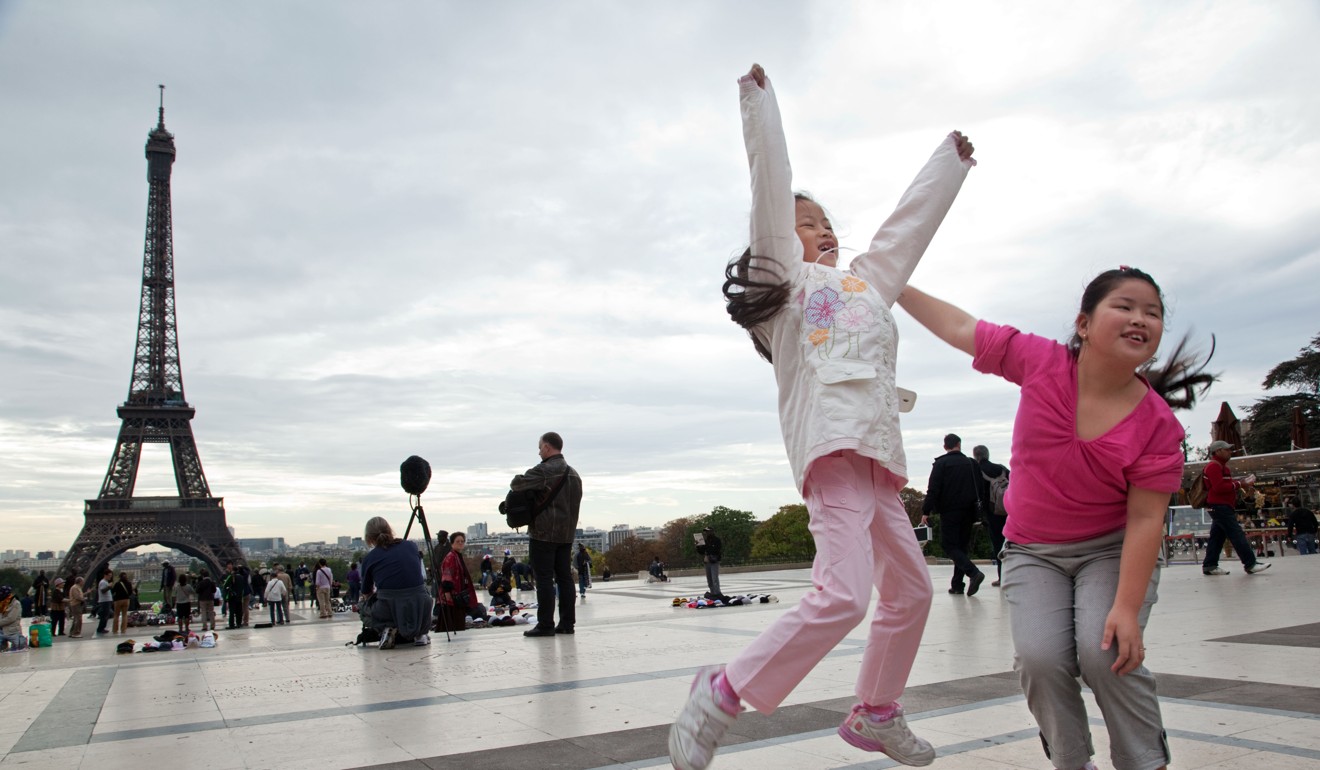 Chinese tourists near the Eiffel Tower in Paris, France. When Chinese spend abroad, this counts in China’s balance of payments as an import of services. Photo: Alamy