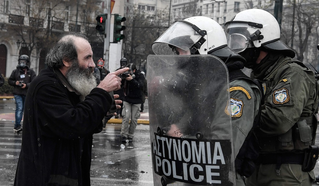 A priest argues with riot police during a demonstration in Athens on Sunday against the agreement with Skopje to rename neighbouring country Macedonia as the Republic of North Macedonia. Photo: AFP