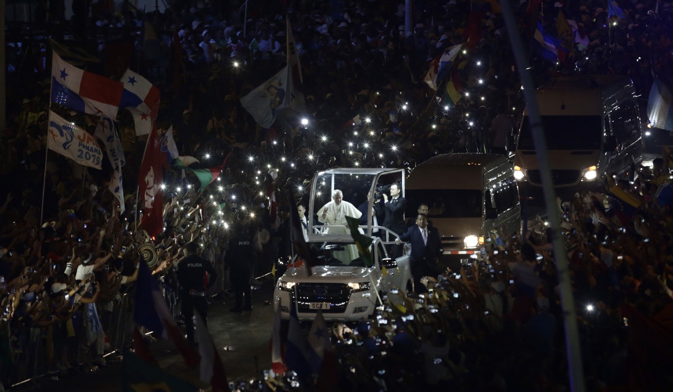 People hold up their cell phones as Pope Francis rides his popemobile in Panama Cityon Thursday. Photo: AP