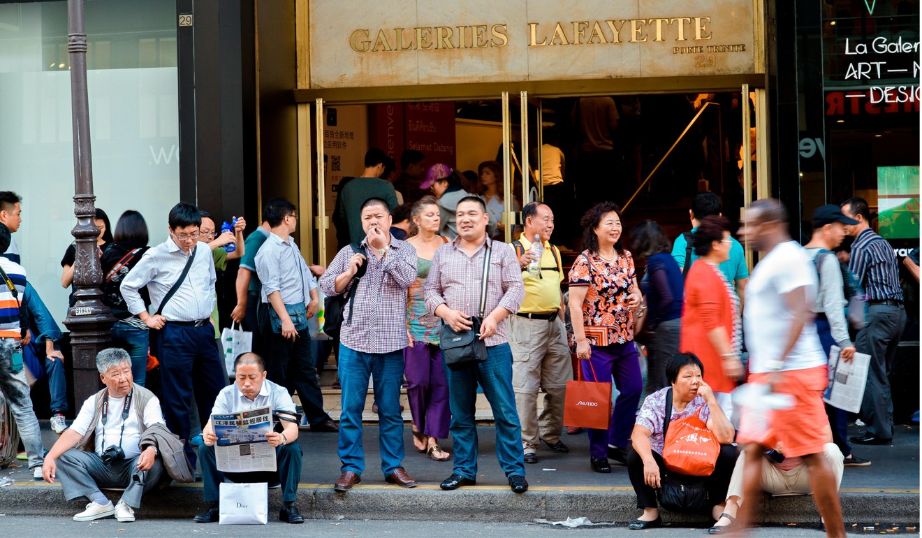 Chinese tourists wait in front of a Paris department store. Photo: Alamy