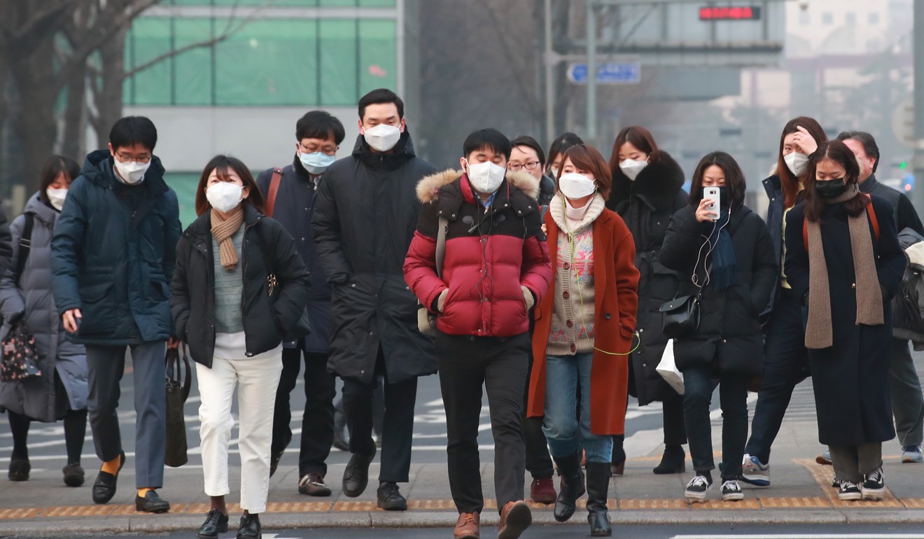 People crossing a street wear masks in downtown Seoul because of the poor air quality. Photo: EPA