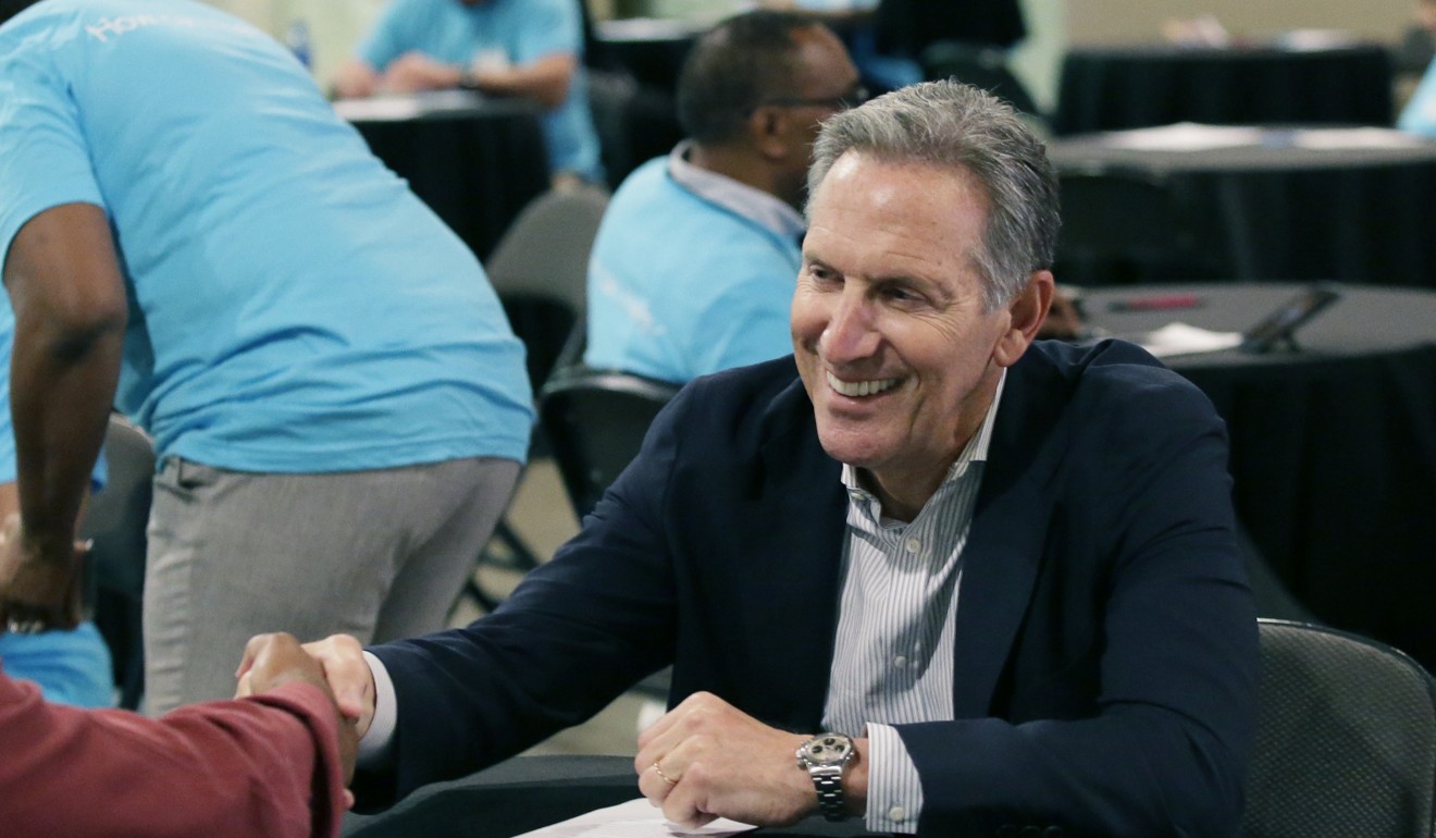 Howard Schultz, right, shakes hands with a jobseeker during the Opportunity Fair and Forum employment event in Dallas in 2017. File photo: AP