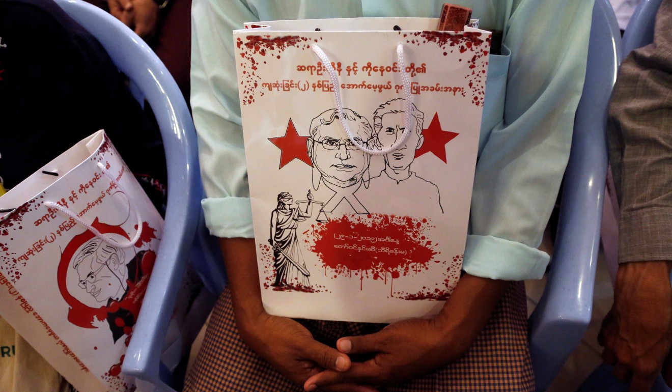 People hold a bag marking the second anniversary of the killing of Ko Ni, a close ally of Aung San Suu Kyi. Photo: Reuters
