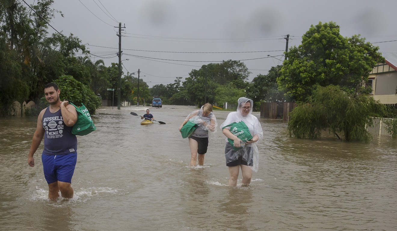 Residents evacuating to higher ground in Hermit Park, Townsville, Queensland. Photo: EPA