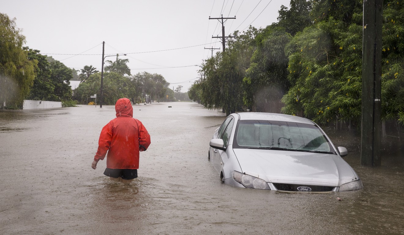 A man walks through floodwater in Rosslea, Townsville, Queensland. Photo: EPA