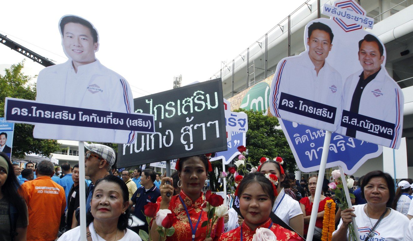 Supporters of pro-junta party Palang Pracharath hold election campaign banners during candidate registration. Photo: EPA