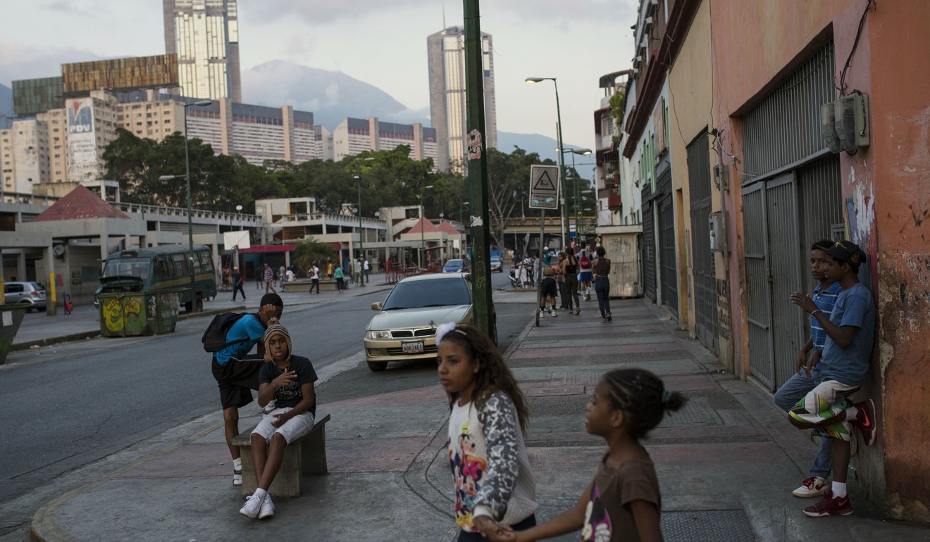 Teenagers gather in a neighbourhood in Caracas, Venezuela. The once-wealthy nation is facing an economic collapse. Photo: AP