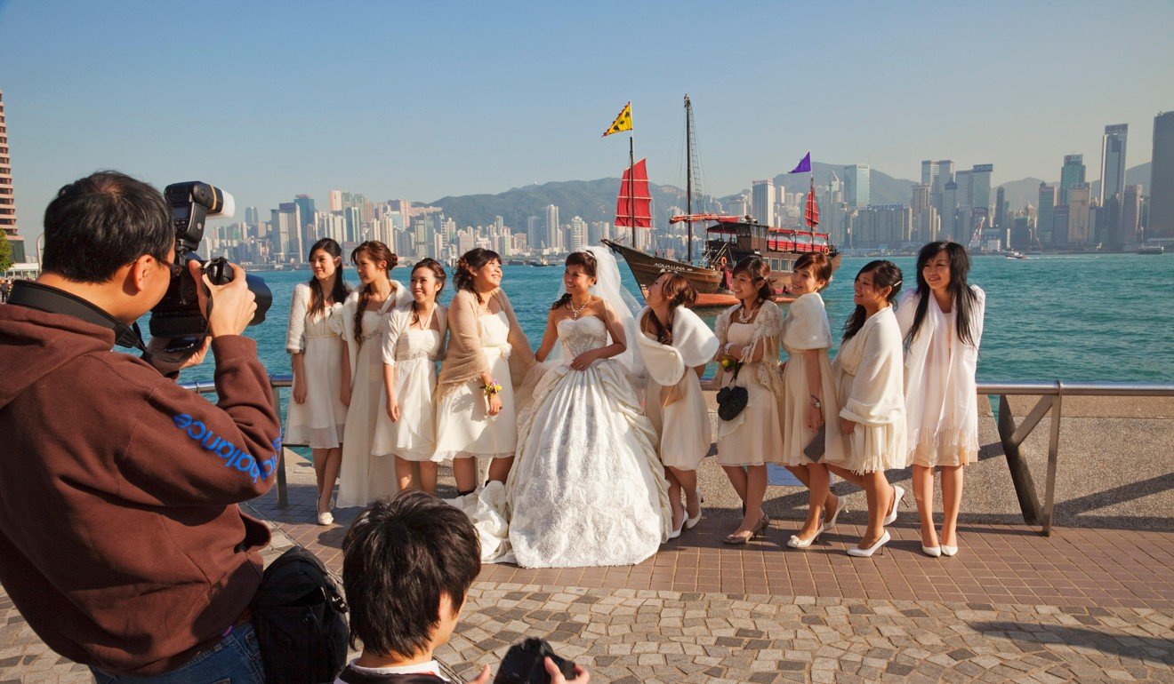 A Hong Kong wedding group enjoy a photoshoot at the Waterfront Promenade, Tsim Sha Tsui. Photo: Alamy