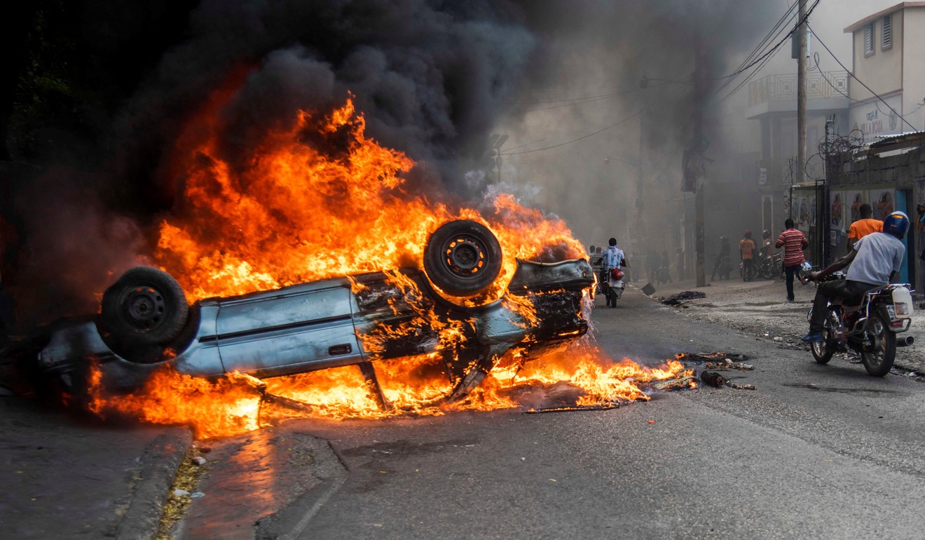 Cars burn after a protest in Port-au-Prince, Haiti. Photo: EPA