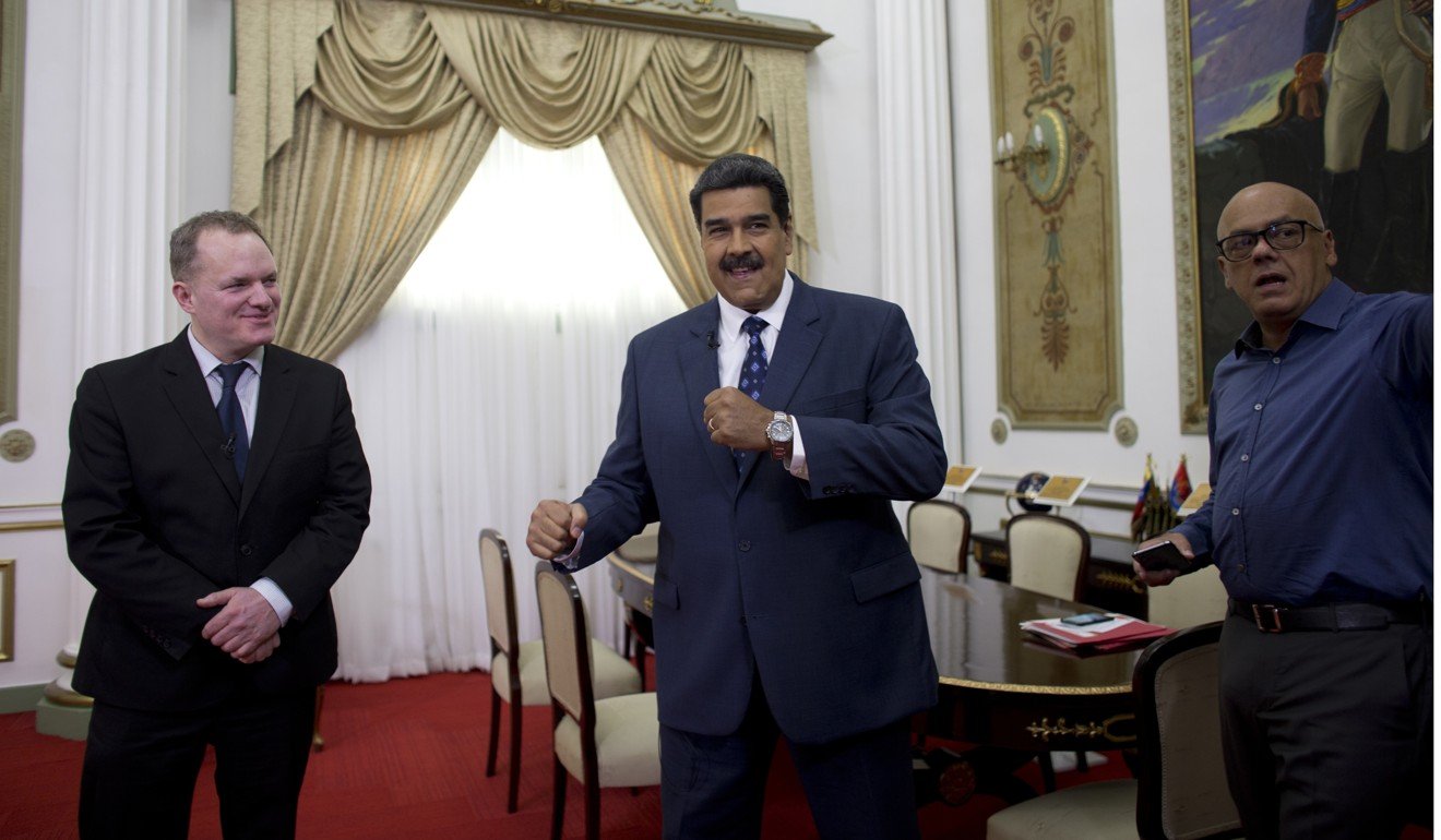 Venezuela’s President Nicolas Maduro jokes with his Communications Minister Jorge Rodriguez (right) before an interview with Associated Press Vice President of International News Ian Phillips at Miraflores presidential palace in Caracas, Venezuela on February 14, 2019. Photo: AP