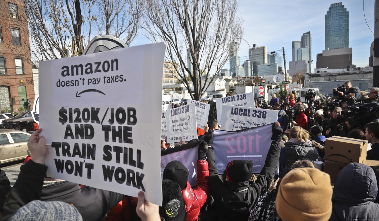 Protesters carry anti-Amazon posters during a coalition rally and press conference opposing Amazon headquarters getting subsidies to locate in the New York. Photo: AP Photo