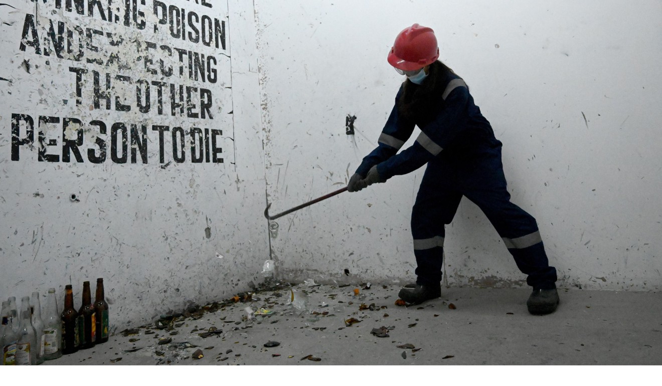 Tanjung, a 20-year-old student, smashes bottles with a crowbar at the Temper Clinic in Jakarta. Photo: AFP
