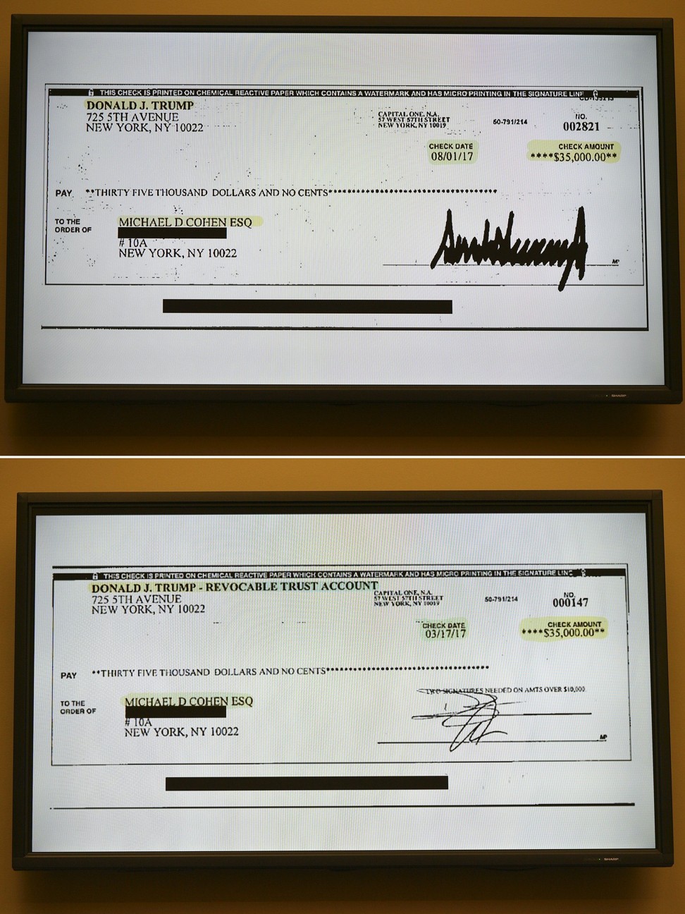 Photos flashed on a screen during Michael Cohen's testimony. The top image shows a cheque signed by Donald Trump in 2017, the bottom cheque was signed by Donald Trump Jnr; Cohen says they were reimbursement for hush money Cohen paid to a porn star on Trump’s behalf. Photo: AFP