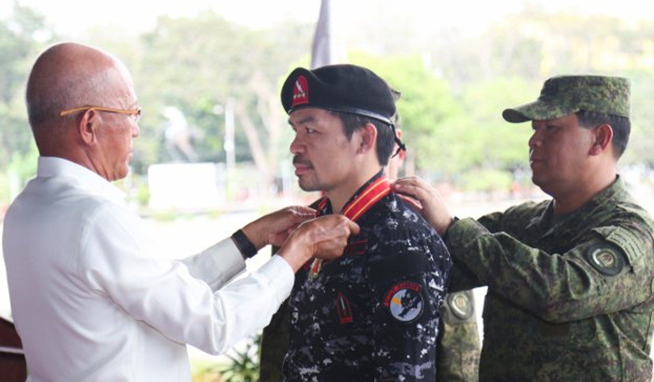 Manny Pacquiao receives his medal from defence secretary Delfin Lorenzana at a ceremony in Quezon City. Photo: Wendell Alinia