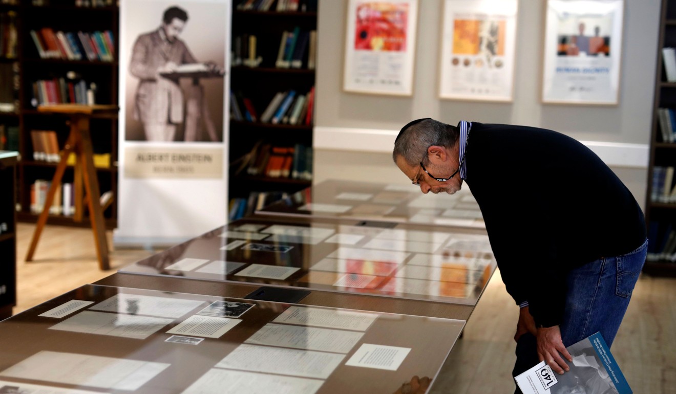 A man checks one of Einstein’s manuscripts on display at the university on Wednesday. Photo: AFP