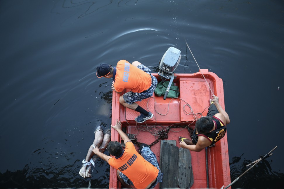 The Philippine Coast Guard brings the body ashore in Tondo, Manila, on January 14. Photo: Lynzy Billing