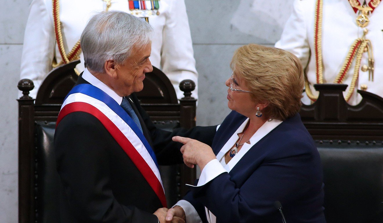 Chilean President Sebastian Pinera (L) is greeted by outgoing President Michelle Bachelet. Photo: AFP