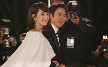 Actress Kim Hye-soo (left) and actor Yoo Yeon-seok, the hosts of last Friday’s Blue Dragon Film Awards, smile for the cameras as they walk on the red carpet before the event in Seoul. Photo: Yonhap