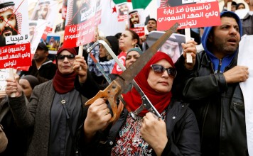 A woman holding two saws at a protest against the visit of Saudi Arabia’s Crown Prince Mohammed bin Salman to Tunisia, in Tunis on November 27, 2018. Photo: Reuters