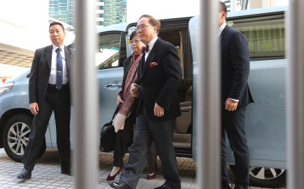 Former chief executive Donald Tsang with his car and bodyguards. Photo: Felix Wong