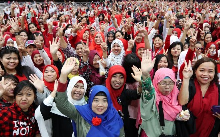 Indonesian domestic helpers cheer at an event to meet Indonesian President Joko Widodo at AsiaWorld-Expo, on April 30. Photo: Edward Wong